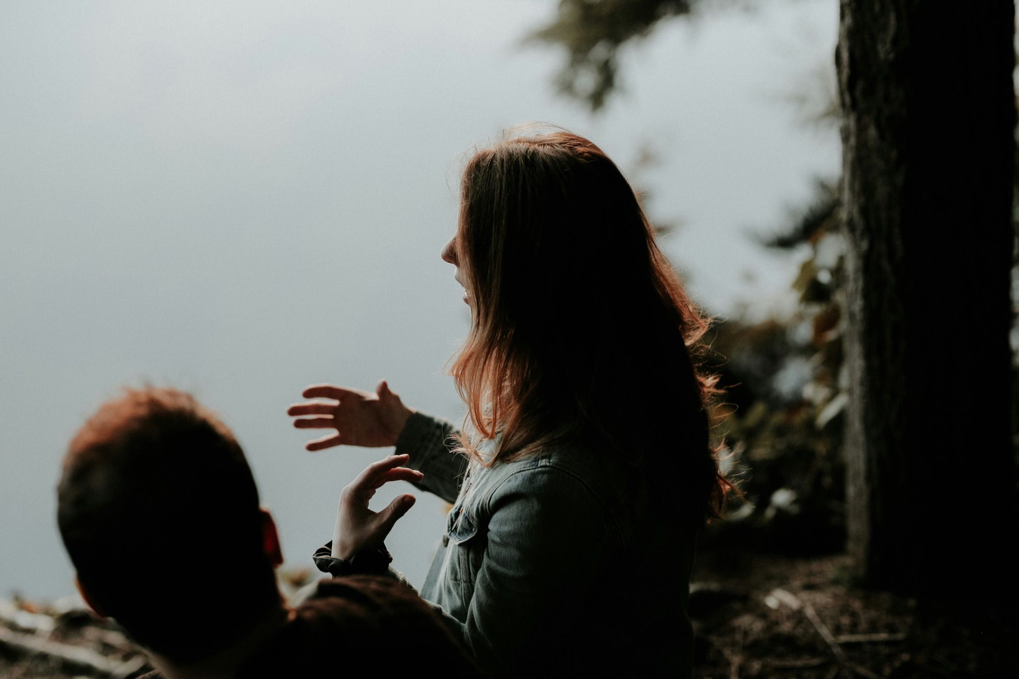 Two people in conversation among the trees