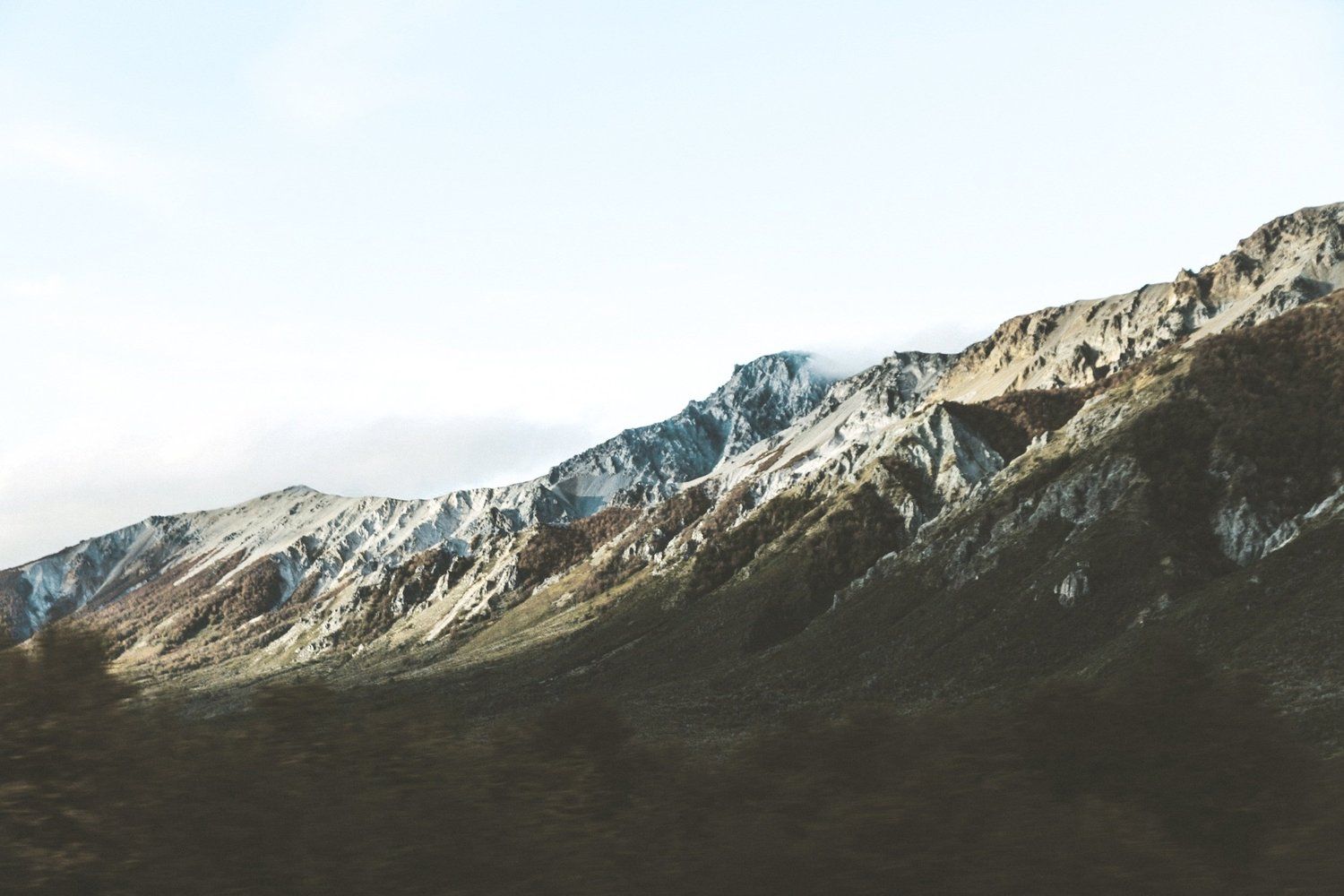 A rocky mountain ridge under a pale sky